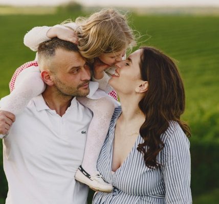 A delightful family moment captured in a lush scenic field, portraying love and happiness.